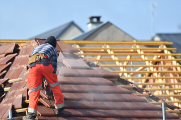 ouvrier couvreur sur un toit d'une construction - 778037014
