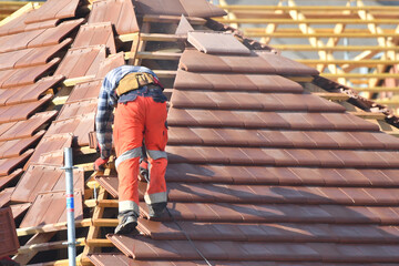 ouvrier couvreur sur un toit d'une construction - 778037024