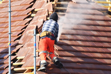 ouvrier couvreur sur un toit d'une construction - 778037048