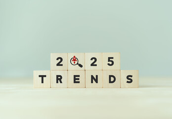2025 trends, emerging markets concept. Wooden cube blocks with 2025, magnifying glass, TRENDS text....