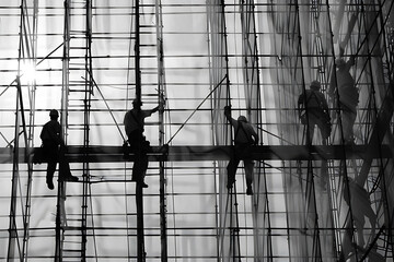 Builders labor on bustling construction site, embodying industriousness, teamwork, and progress in urban development