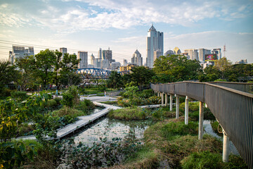 Sunset in the afternoon at Benchakitti Park. Golden hour view in the park with pathway and nature all around © Wichakorn