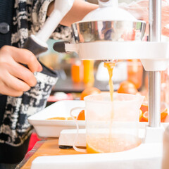 The orange juice shop on the street, which uses fresh oranges to make drinks, is very popular with the common people.