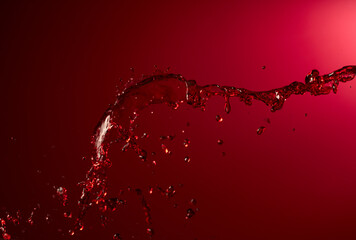 Red wine splash on a dark red background.