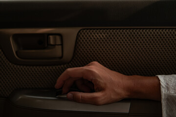 woman hand resting on an armrest in a car, traveling background