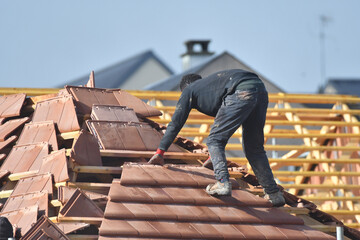 ouvrier couvreur sur un toit d'une construction - 778055202