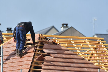 ouvrier couvreur sur un toit d'une construction - 778055270