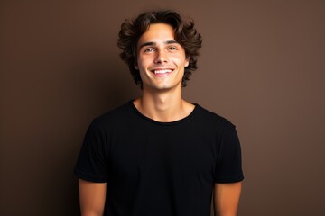 Fototapeta premium A young man with a black shirt is smiling and looking at the camera