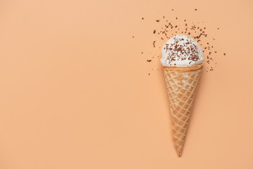 Ice cream in a waffle cone with chocolate chips on a pastel background. Top view, flat lay,...