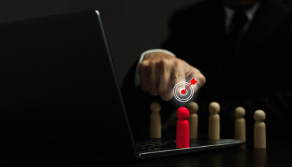 A man is pointing at a red target on a laptop screen