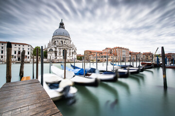 Panoramic beautiful view of traditional venetian gondolas moored in water of Grand Canal in front...