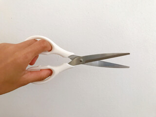 white scissors cutting a piece of paper