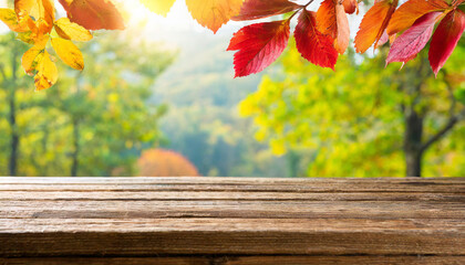 Naklejka na ściany i meble Wooden table and blurred Autumn background. Autumn concept with red-yellow leaves background
