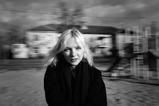Portrait of a young beautiful blonde girl outdoors. Black and white photo.