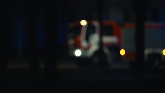 Blurred image of a fire truck with automotive lighting at night