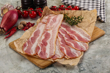 Sliced pork bacon over board