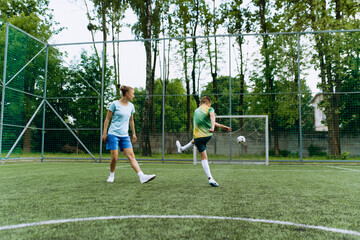 A girl coach and a boy at football training. Training for two with a ball