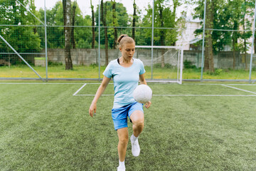 girl soccer player works with the ball on the soccer field