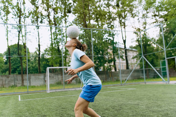 soccer player girl juggles the ball on her head. Football player in training