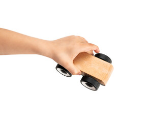 High angle shot of a child hand playing with miniature wooden toy cars,against a white background .