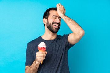 Young man with a cornet ice cream over isolated blue background has realized something and intending the solution