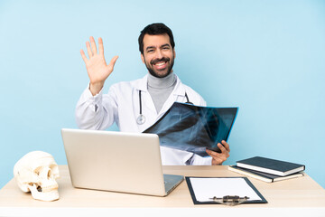 Professional traumatologist in workplace saluting with hand with happy expression