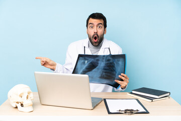 Professional traumatologist in workplace surprised and pointing finger to the side