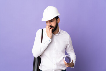 Young architect man with helmet and holding blueprints over isolated purple background having doubts
