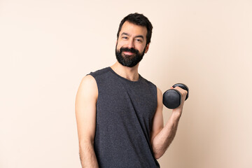 Caucasian sport man with beard making weightlifting over isolated background keeping the arms...
