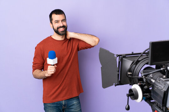 Reporter man holding a microphone and reporting news over isolated purple background laughing