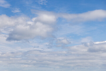 The tranquil beauty of a light blue sky, interspersed with the textured relief of cumulus clouds,...