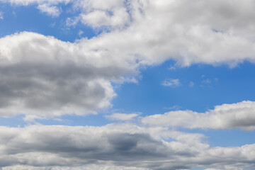 Fototapeta premium The expanse of the sky unfolds in canvas of light blue, adorned with fluffy cumulus clouds stretching into the horizon. Ideal for backgrounds