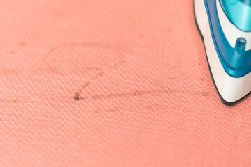 Close up of stain of dirt on clothes after ironing. Iron on cloth with spot of dirt	
