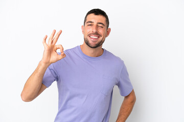 Young handsome caucasian man isolated on white background showing ok sign with fingers