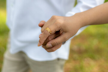 selective focus gold diamond ring on the young woman's hand He is holding a young woman's hand...