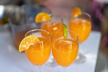 selective focus tangerine slices on the lip of a glass of freshly squeezed orange juice Fresh fruit juice drinks from the orange orchard to taste orange juice.