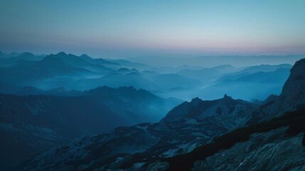 Layer upon layer of mountain ranges enveloped in mist under the ethereal twilight sky. - obrazy, fototapety, plakaty