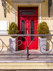 A classic design house entrance with a bright red door. Travel to Athens, Greece. - 778115048