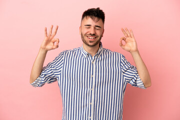 Young caucasian man isolated on pink background in zen pose