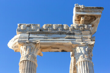 Detailed view of the ornate mask frieze on Apollo Temple in Side, set against a clear blue sky. Side, Manavgat, Turkiye (Turkey) - obrazy, fototapety, plakaty