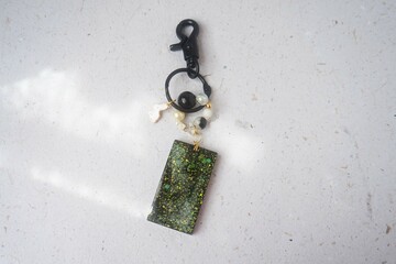 Key chain / bag charm on greyish white background. Top view.