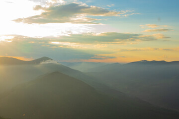
sunset in the mountains, evening mist drifts into the valleys, watercolor sky, sunlight dissolves...