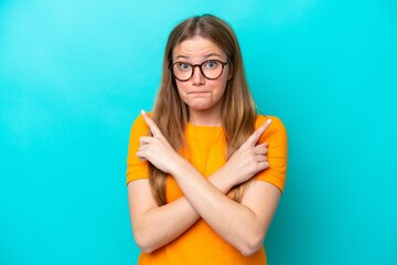 Young caucasian woman isolated on blue background pointing to the laterals having doubts