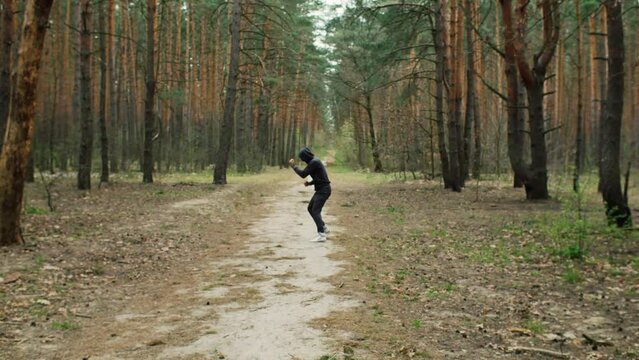 Boxer man traning in the forest. Shadow boxing. Boxer jog. Sport motivation. Outdoor training