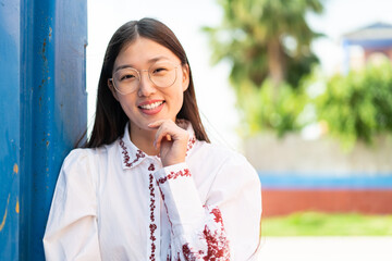 Young Chinese woman at outdoors With happy expression