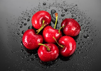 Cherries on gray background. Fresh ripe Cherry berries close-up. Organic red cherries with water drops on grey background. Heap of juicy organic Berries, vegan food. Top view. 