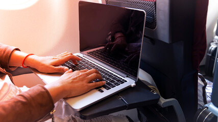 Nomad digital woman hand  as she is a freelance working  a vacation with laptop in  Airplane