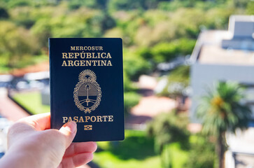 high angle shot of an Argentine passport with Buenos Aires in the summer background. Travel concept