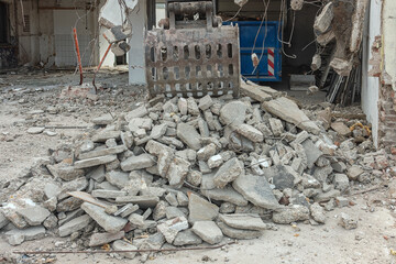 concrete blocks with steel reinforcement are sorted by a steel bucket of a bulldozer
