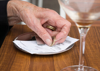 Old hand and money. Elderly person paying a bill